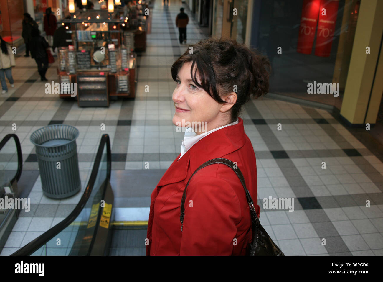 Frau auf der Rolltreppe an ein New York Shopping-Mall auf der Suche nach Schnäppchen. Stockfoto