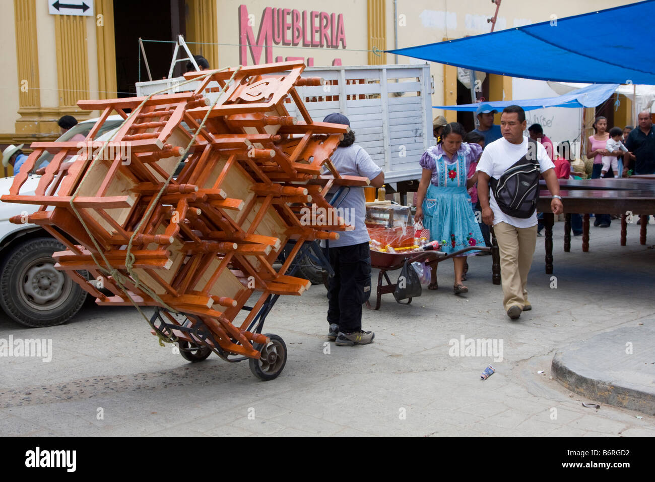 Tlacolula, Oaxaca, Mexiko. Tlacolula Market. Mann, die Stühle auf einem fahrbaren Dolly bewegen. Stockfoto