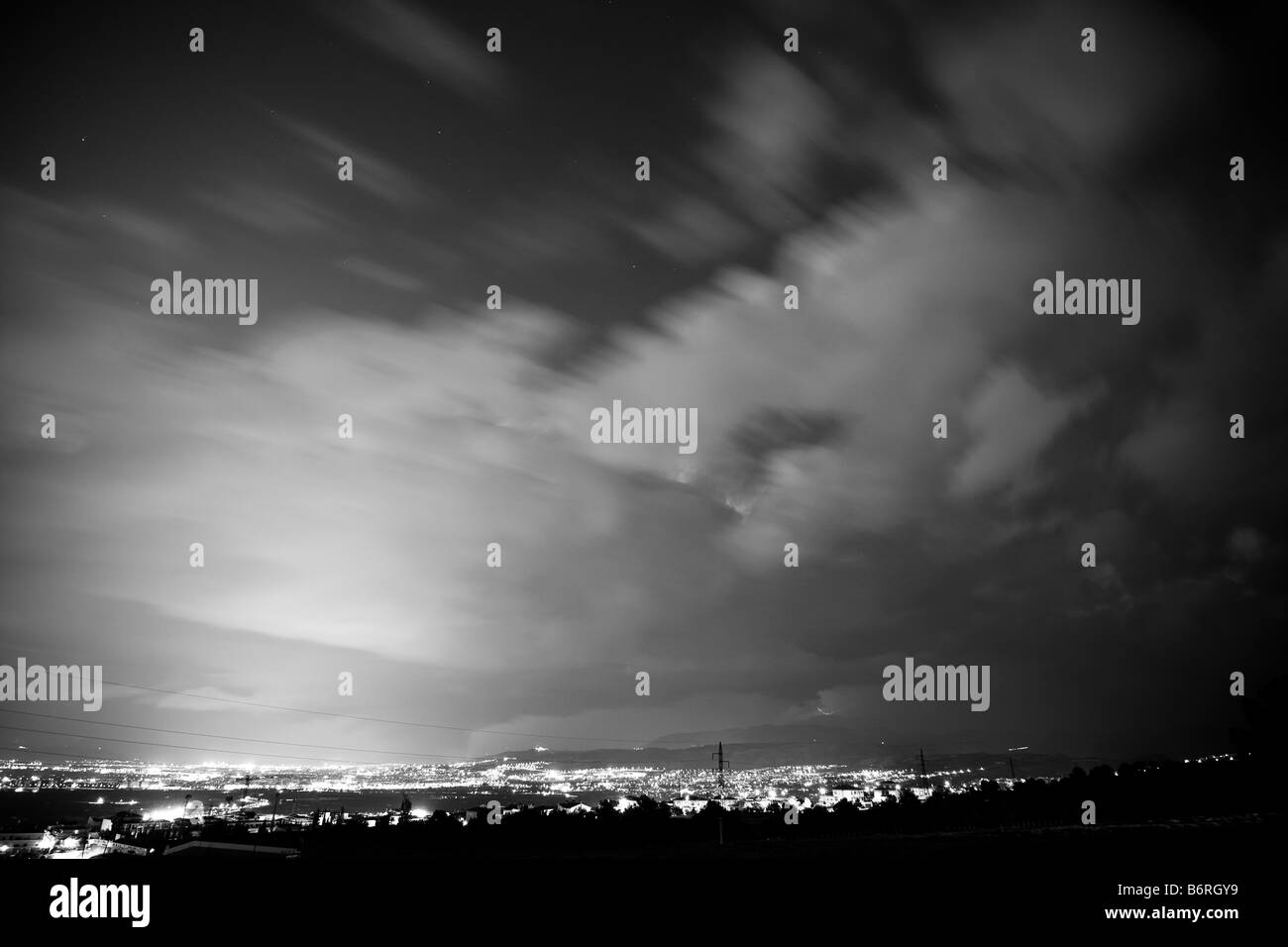 Lange ausgesetzt Wolkengebilde über der Stadt und schwarz getönt Stockfoto