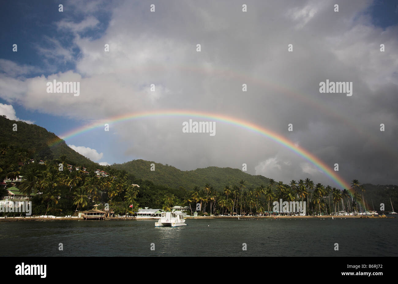 Ein Regenbogen erscheint über ein Wildschwein, das Segeln in Marigot Bay, St. Lucia, Windward-Inseln, Karibik in den West Indies festgemacht. Stockfoto