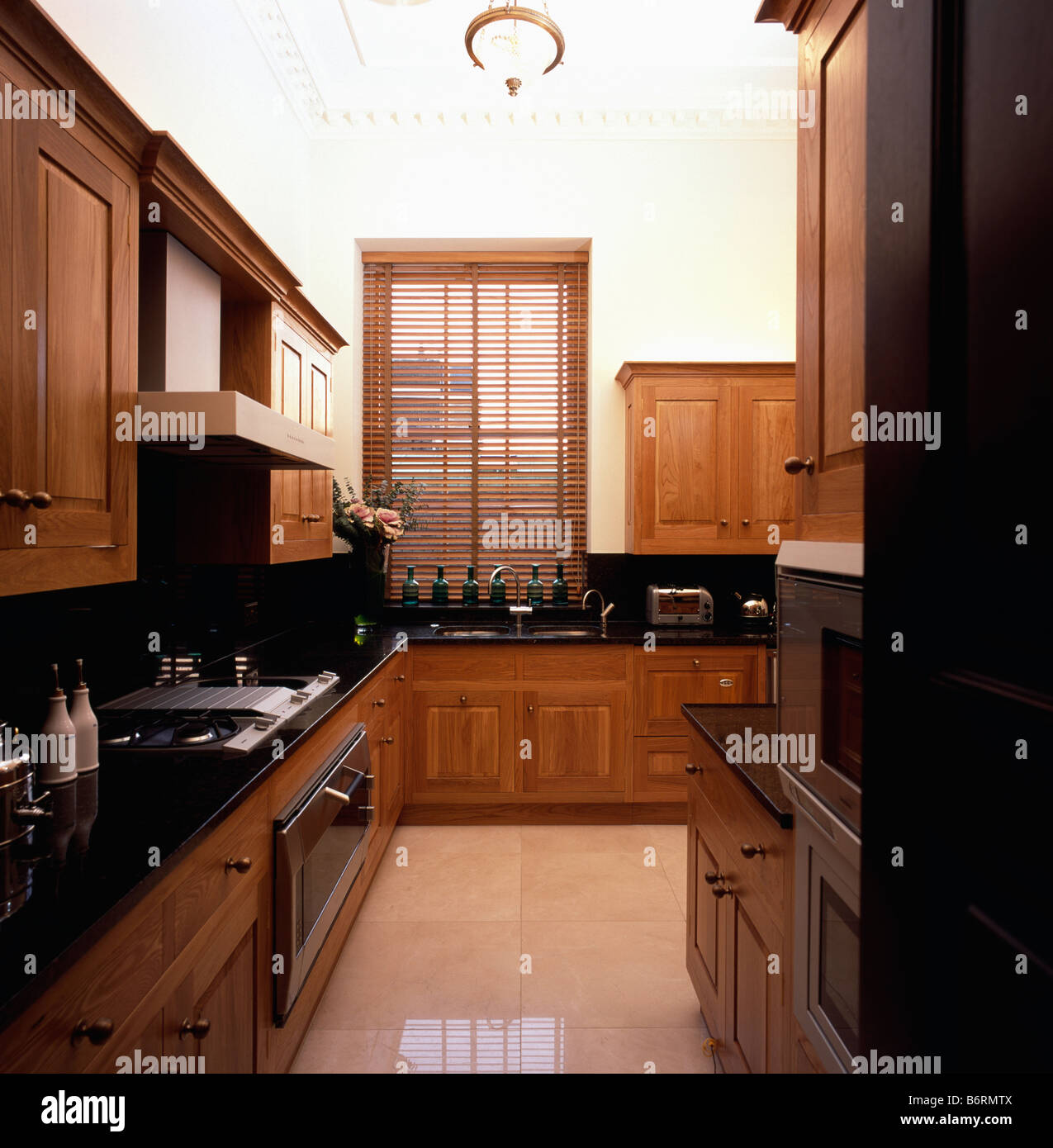 Lattenrost aus Holz blind und Marmor Fliesenboden in modernen Küche mit Einbauschränken aus Holz Stockfoto