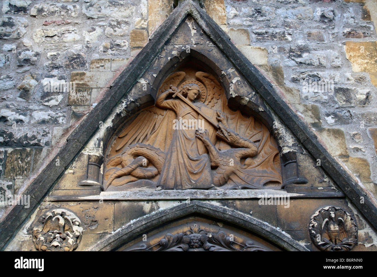 Schnitzerei über einer Tür von saint George, der den Drachen Llandaff Kathedrale in Cardiff, Wales, die britische Kirche, tötete religiöse Steinmetzarbeiten Stockfoto