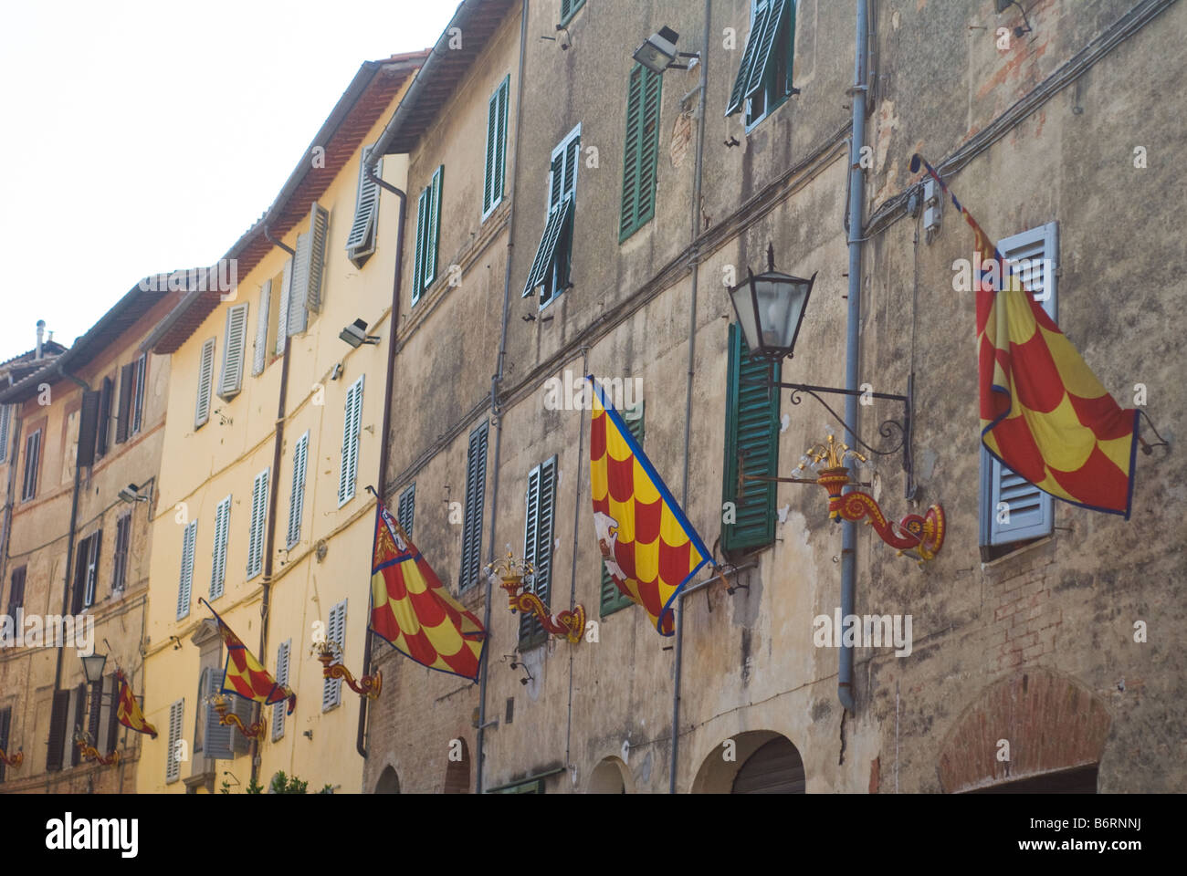 Flaggen der Contrada della Chiocciola (rot, gelb und blau) in Vorbereitung auf das berühmte Pferderennen Pailo, Siena, Toskana, Italien Stockfoto