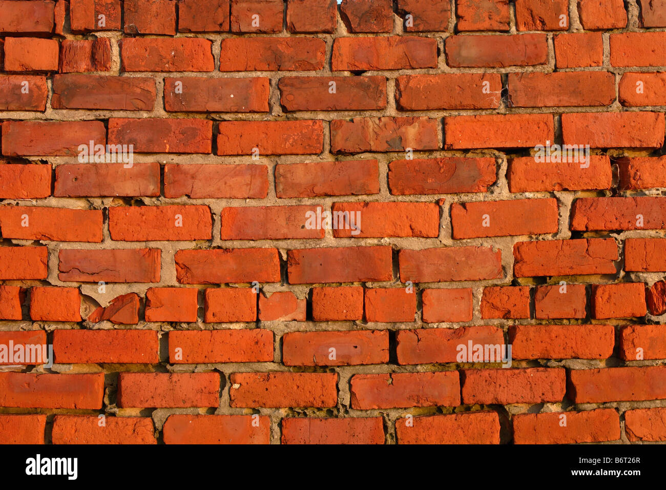 Roten Backsteinmauer mit Lücken in den Mörtel zeigt Stockfoto