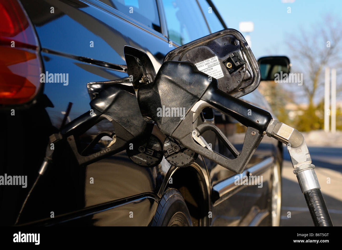 Düse eingefügt in ein schwarzes Auto, während Sie Tanken an einer Tankstelle mit roten Bremsleuchte Toronto Stockfoto