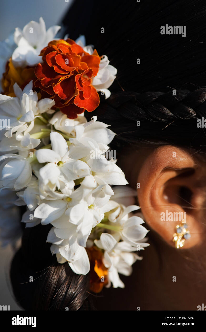 Jasmin und Ringelblume Blüten in einem indischen Mädchen Haare. Andhra Pradesh, Indien Stockfoto