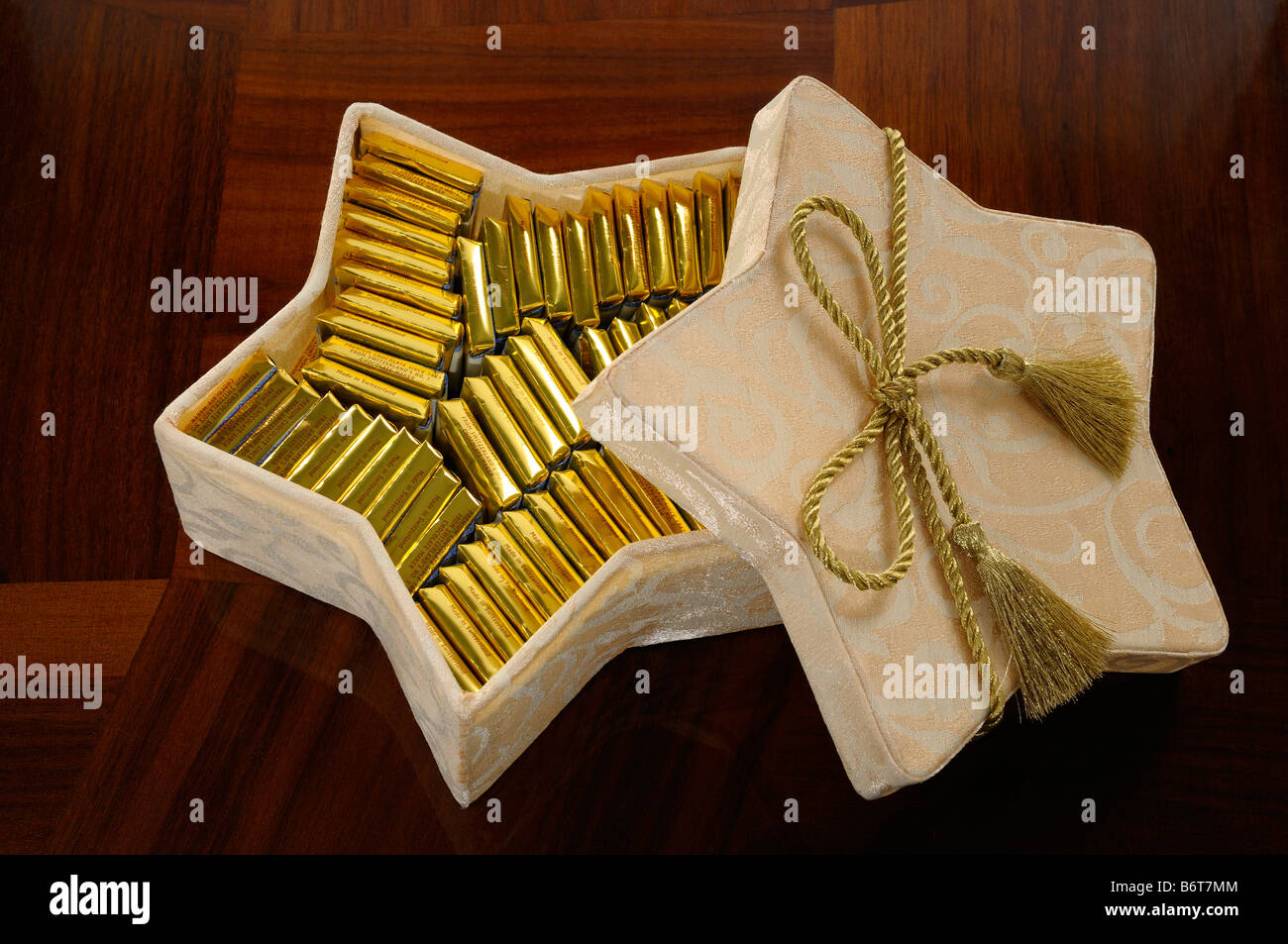 Goldbarren von Schweizer Schokolade in einem Stern förmigen Box auf einem Holztisch Stockfoto