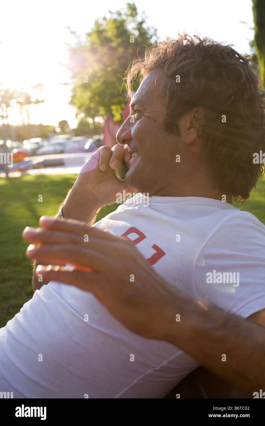 Mann mit einem Gespräch auf mobile Outdoor in den Sonnenstrahlen Stockfoto