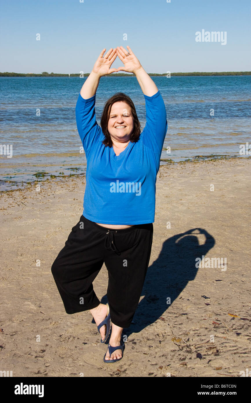 Hübsche Plus size Frau Training am Strand Stockfoto