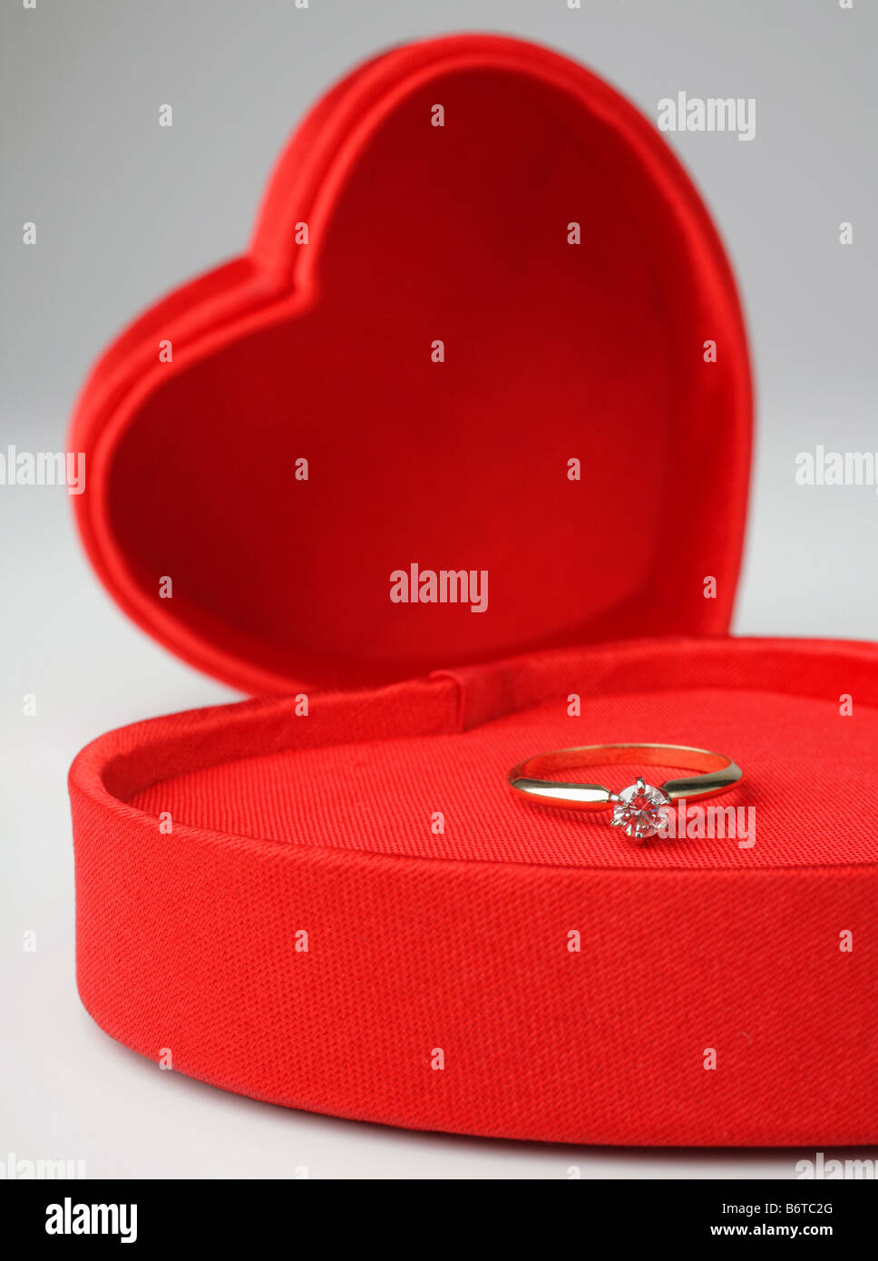 herzförmigen Valentinstag Box mit Deckel und Diamant-Ring im Inneren auf weißem Hintergrund Stockfoto