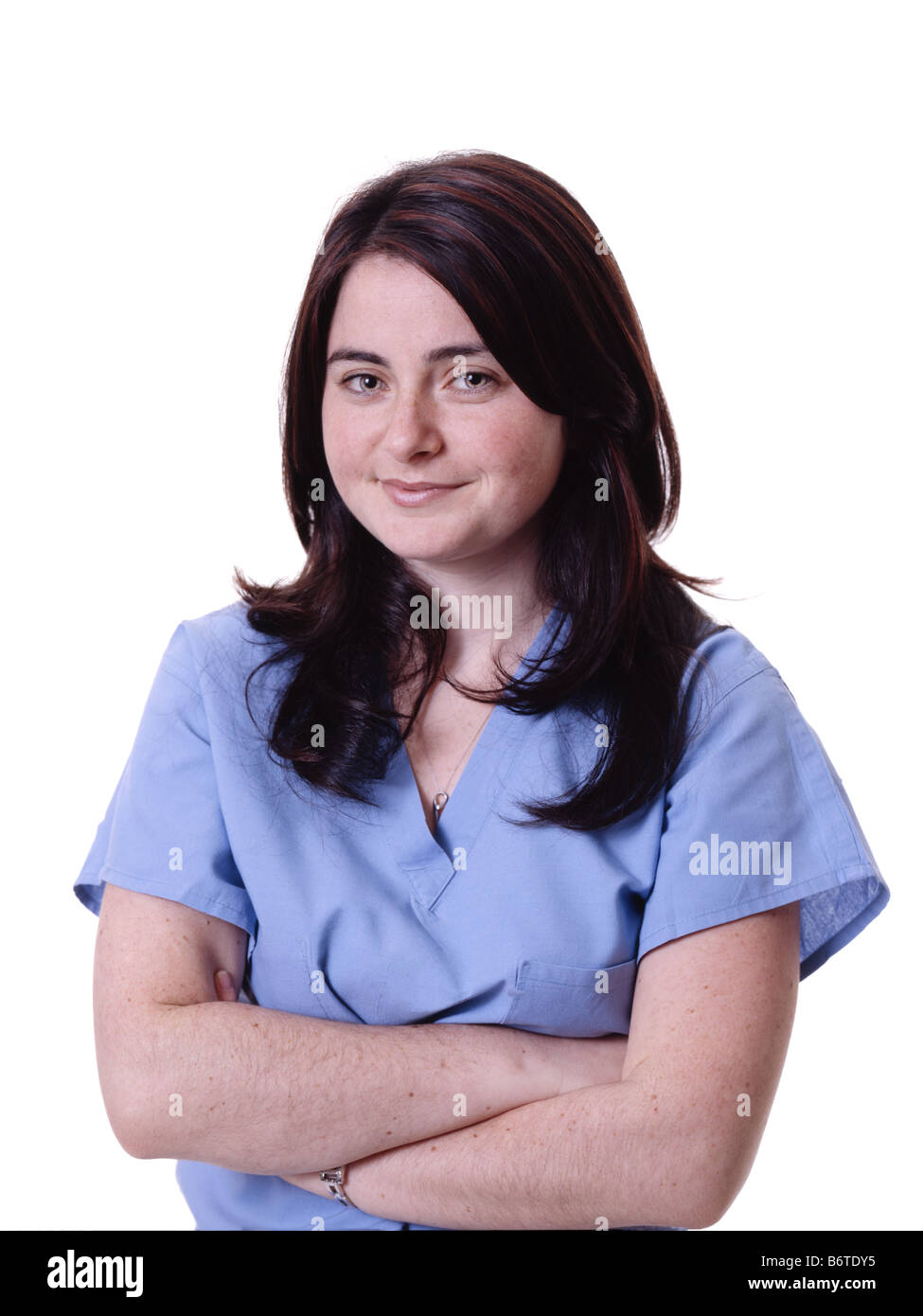 Kopf und Schultern Schuss des Lächelns weiblichen Arzt in Scrubs vor weißem Hintergrund Stockfoto