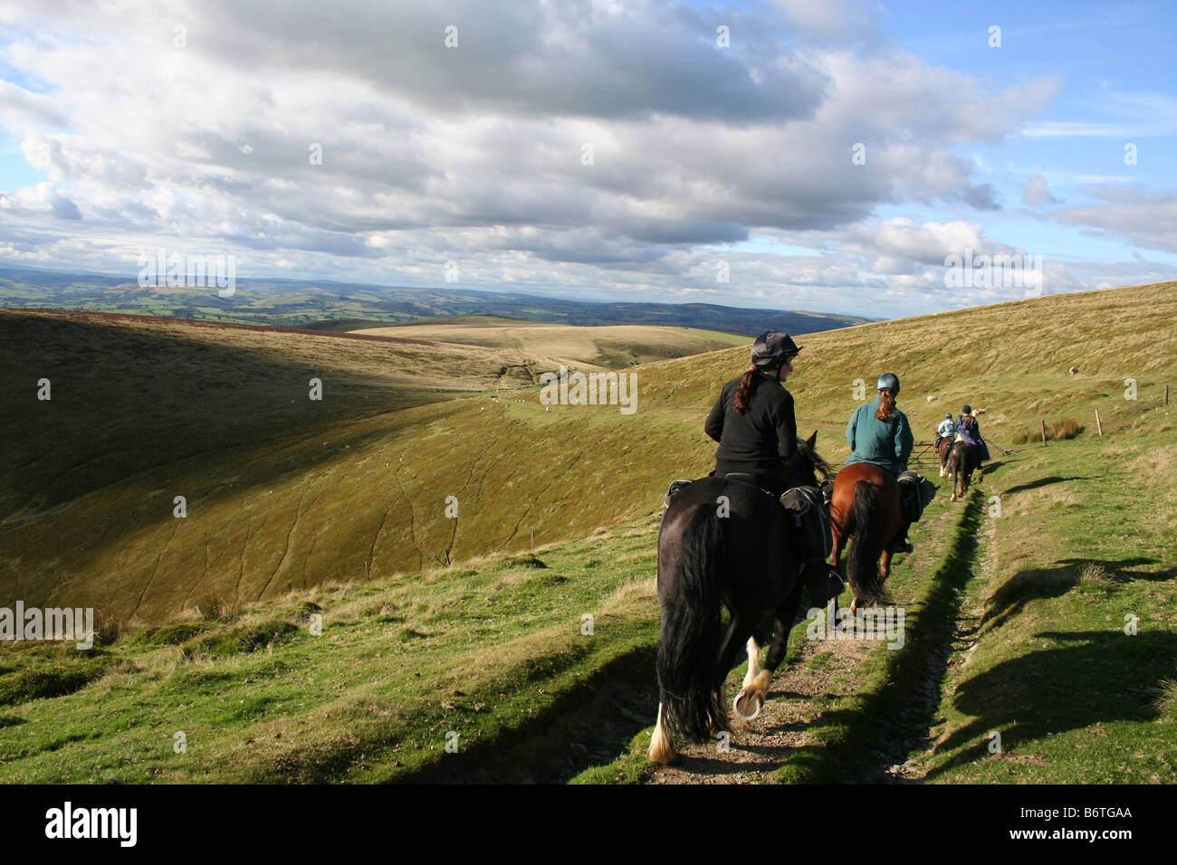 Drei Pferde & Fahrerinnen auf abgelegenen Moorland verfolgen am Abend Licht, während Trans Cambrian Pferd trek über Mid-Wales Stockfoto