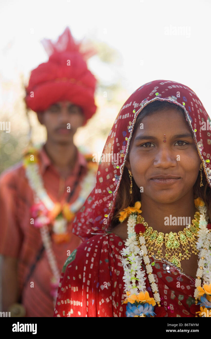 Porträt einer Braut mit ihrem Bräutigam im Hintergrund, Udaipur, Rajasthan, Indien Stockfoto