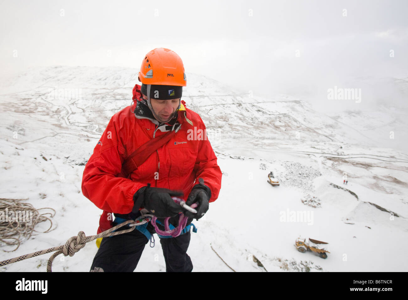 Mountain Rescue Team-Mitglied bereitet Abseilen im Schnee oben Kirkstone in der Nähe von Ambleside in der Seenplatte-UK Stockfoto