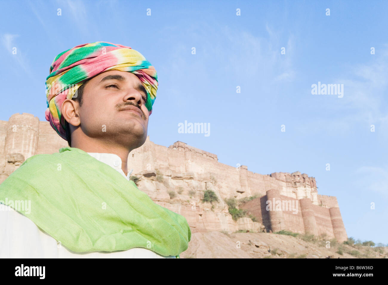 Mann mit Festung im Hintergrund, Meherangarh Fort, Jodhpur, Rajasthan, Indien Stockfoto