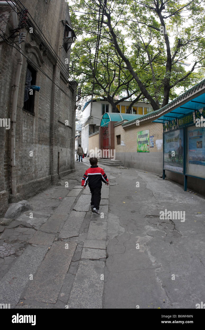 Chinesischen jungen laufen / überspringen durch Gasse Weg Stockfoto