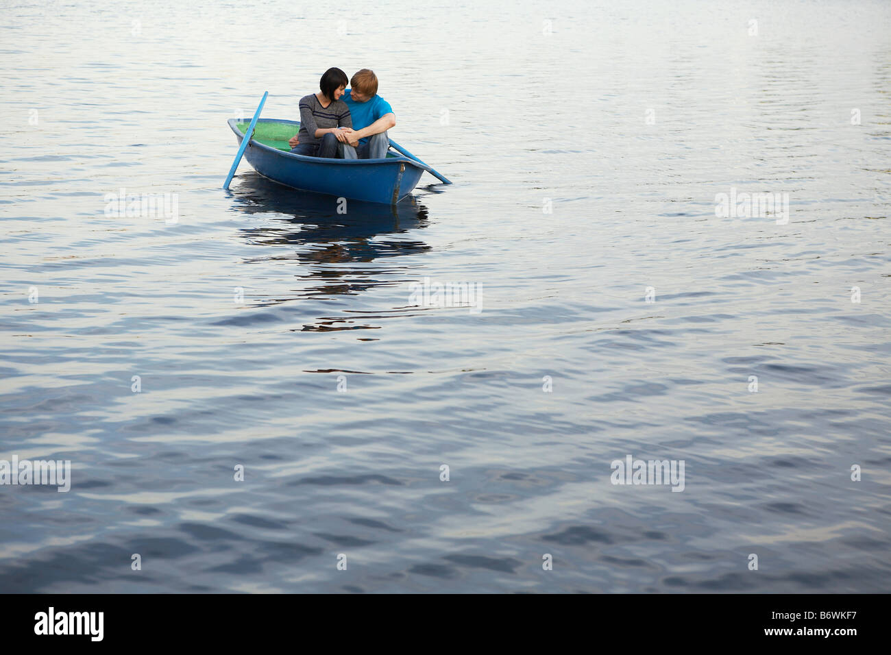 Junges Paar kuscheln im Ruderboot am See Stockfoto