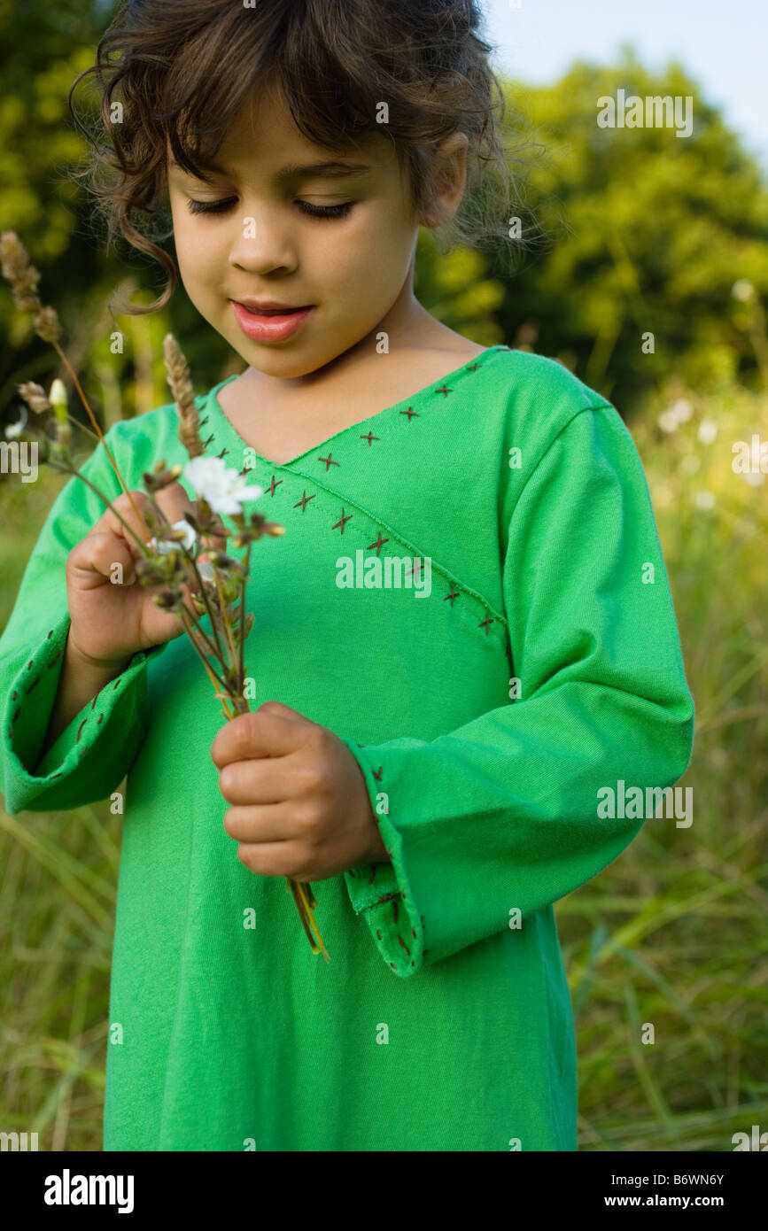 Ein Mädchen hält Bündel von Wildblumen Stockfoto