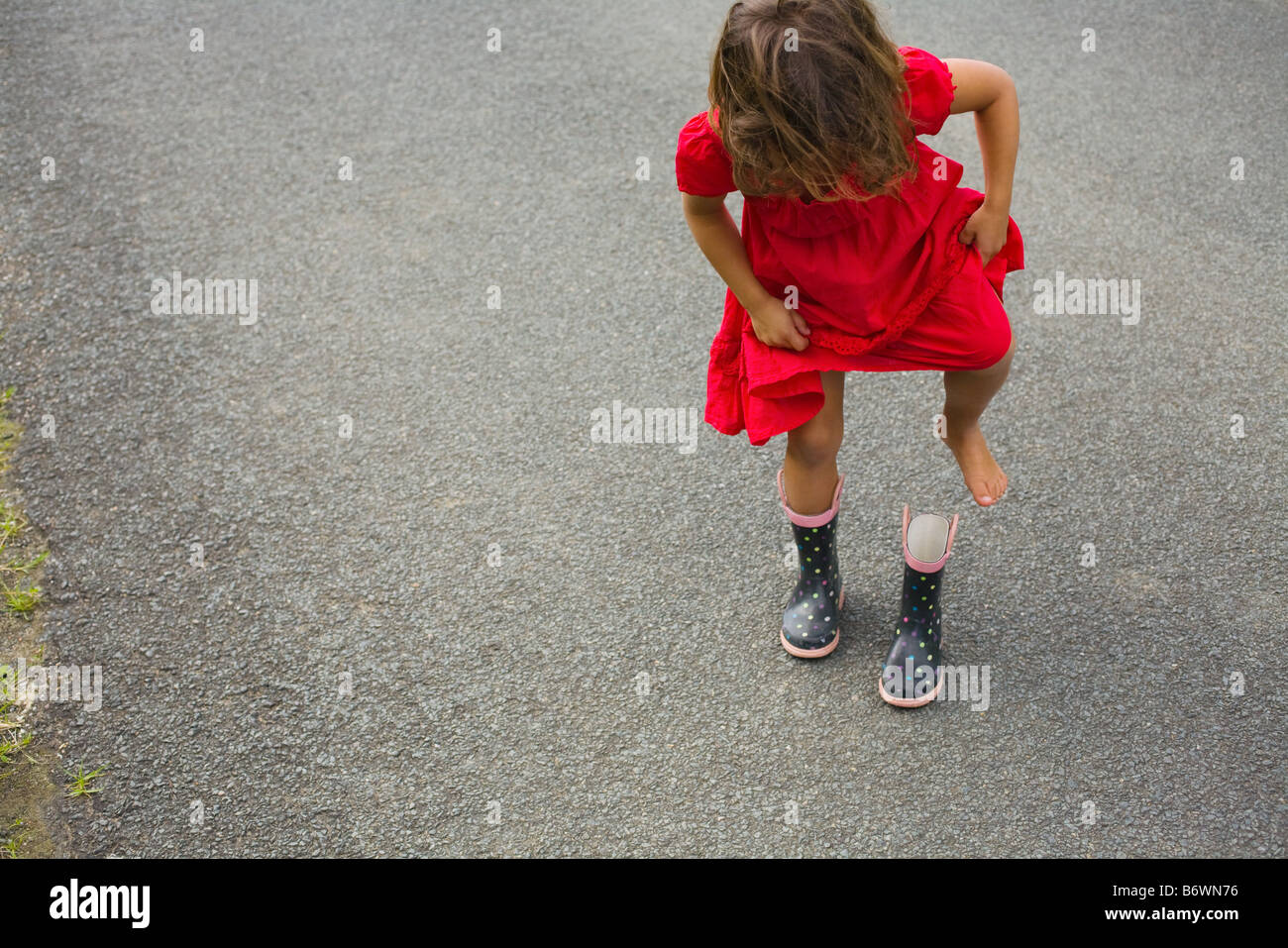 Ein Mädchen heben ihren Fuß aus einem Gummistiefel Stockfoto