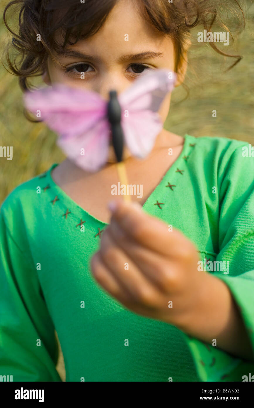 Ein Mädchen hält einen Spielzeug Schmetterling Stockfoto