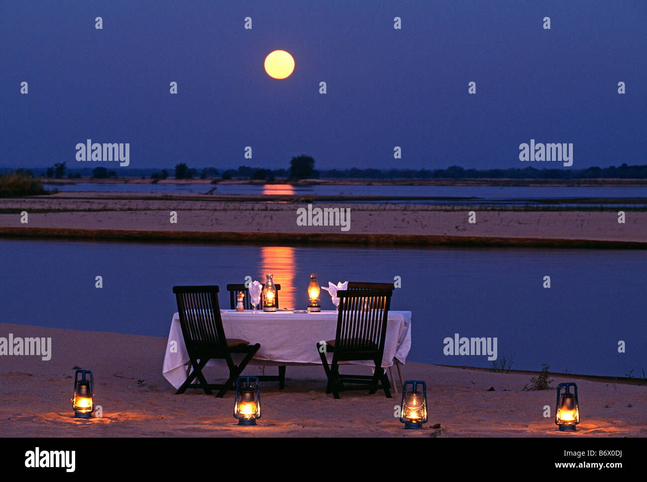 Sambia, Lower Zambesi Nationalpark. Mondschein Abendessen auf einer Insel in der Mitte des Sambesi Stockfoto