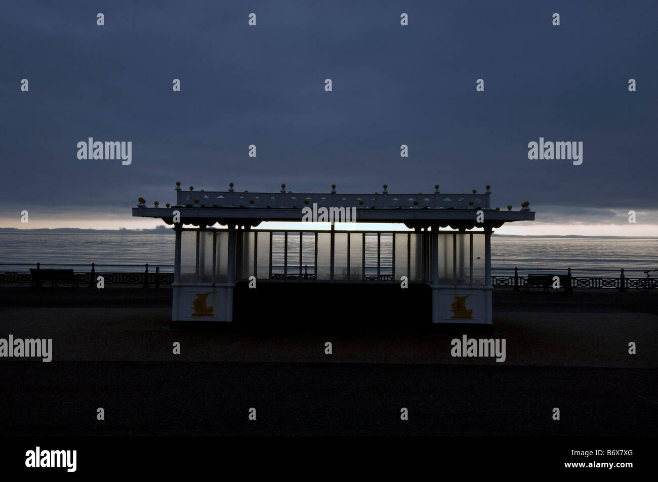 Eine Promenade Schutz gegen ein dunkler werdenden Himmel auf dem Abschlussball an Brighton und Hove Strandpromenade Stockfoto