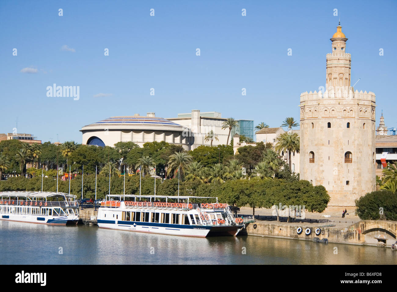 Sevilla Spanien der Torre del Oro mit Ausflugsbooten vorne auf dem Fluss Guadalquivir Stockfoto