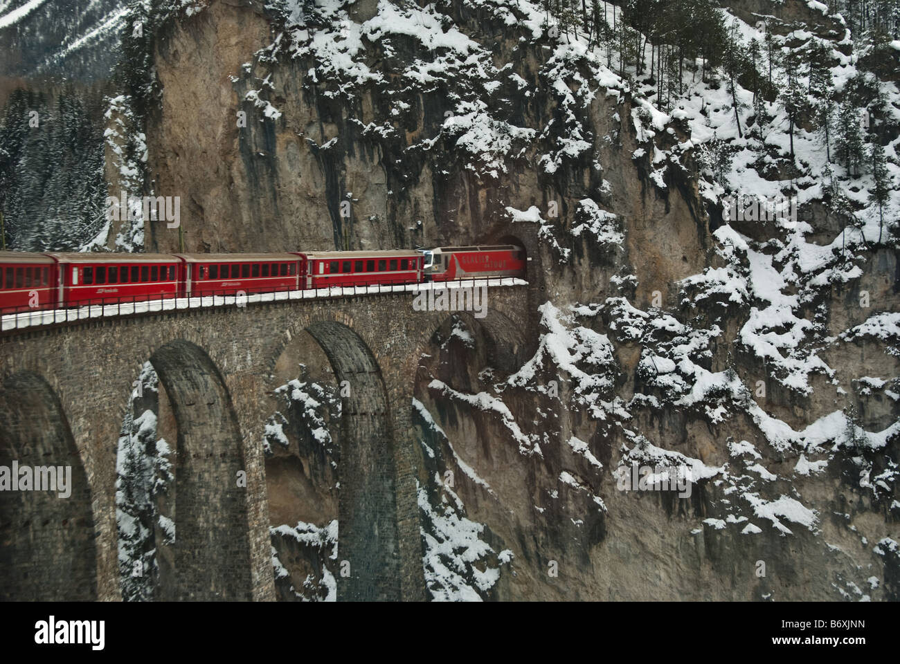 Roter Zug, der auf der Schnellfahrstrecke Bernina in den Tunnel einfährt, Schweiz Stockfoto