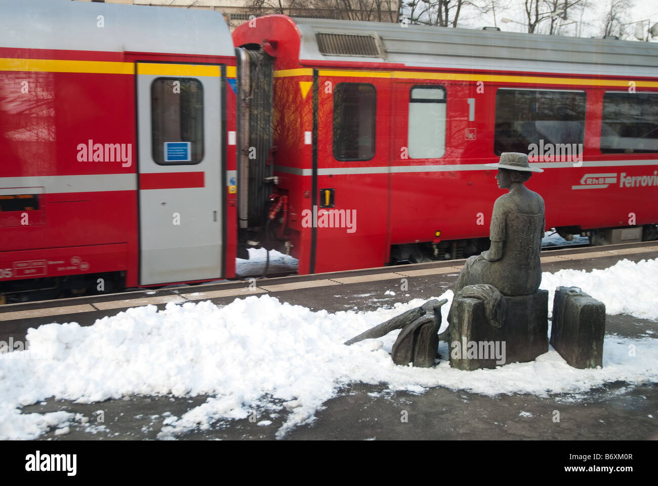 Eine Statue eines Passagiers, der auf dem Bahnsteig auf der Bernina-Express-Strecke in der Schweiz wartet Stockfoto