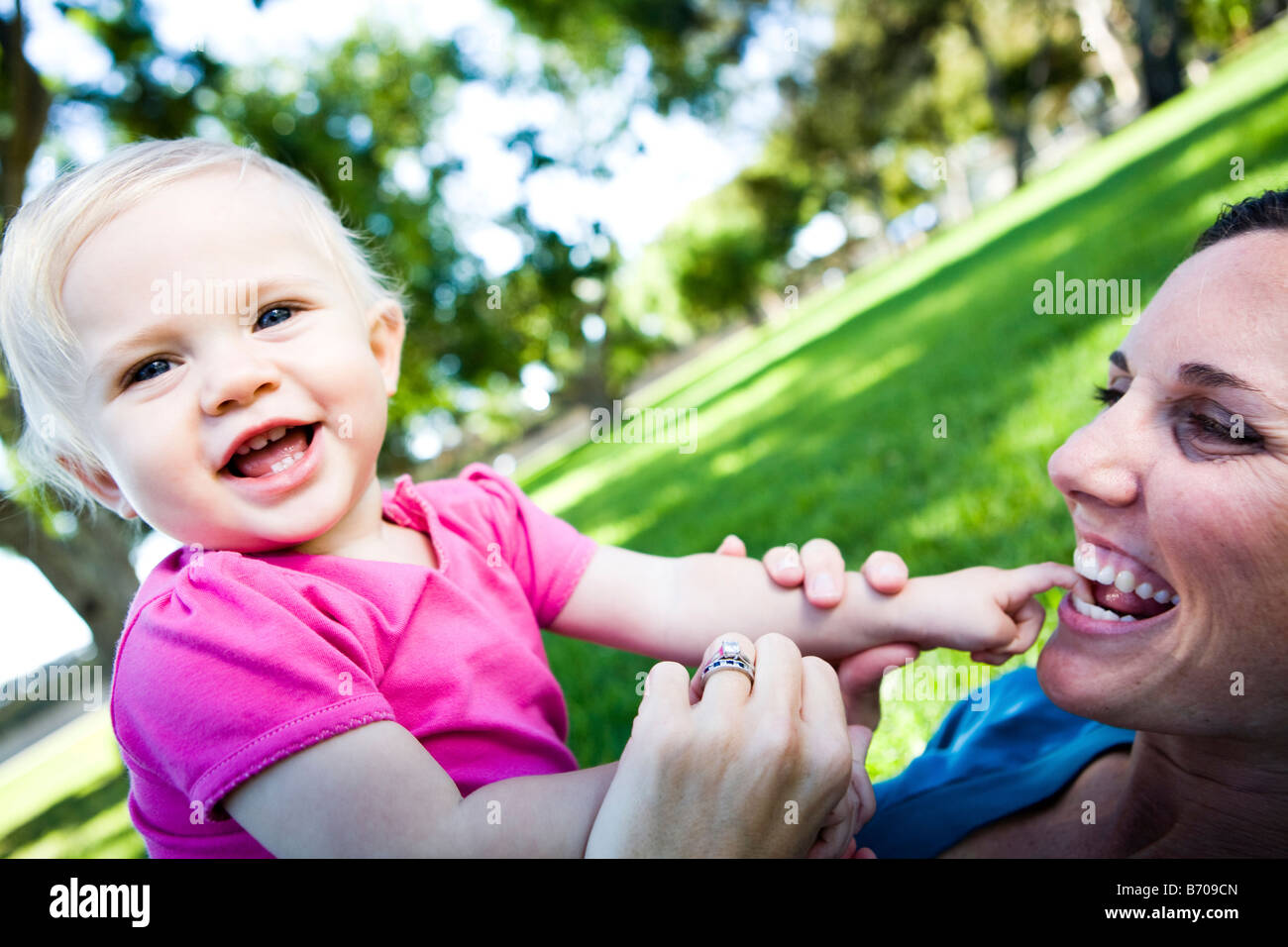 Einjähriges Mädchen und Mama spielen im Park. Stockfoto