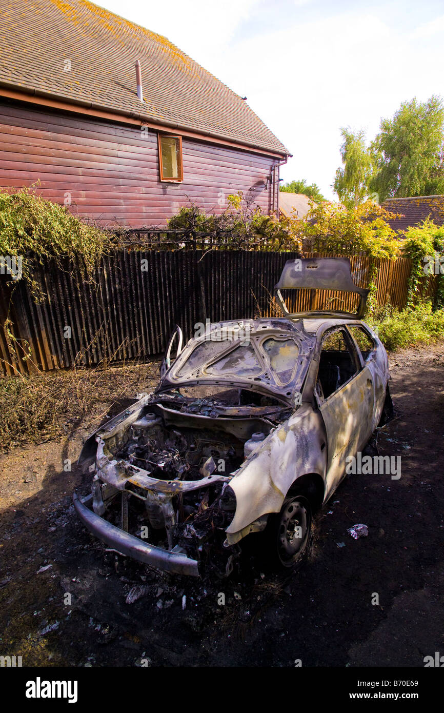 Auto in Gasse in der Nähe von Wohnhäusern ausgebrannt Stockfoto