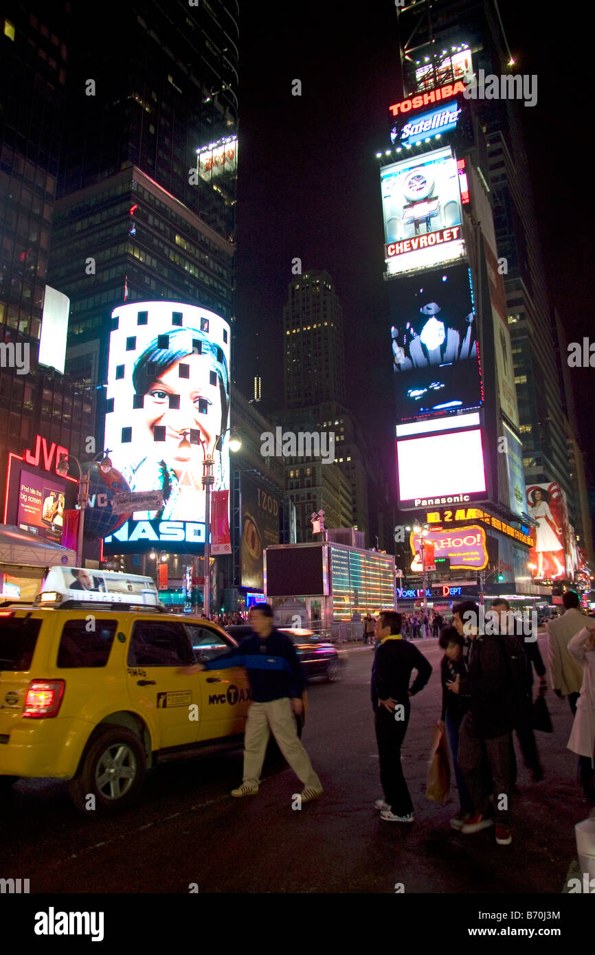 Menschen, die mieten ein Taxi auf dem Times Square bei Nacht Manhattan New York City New York USA Stockfoto