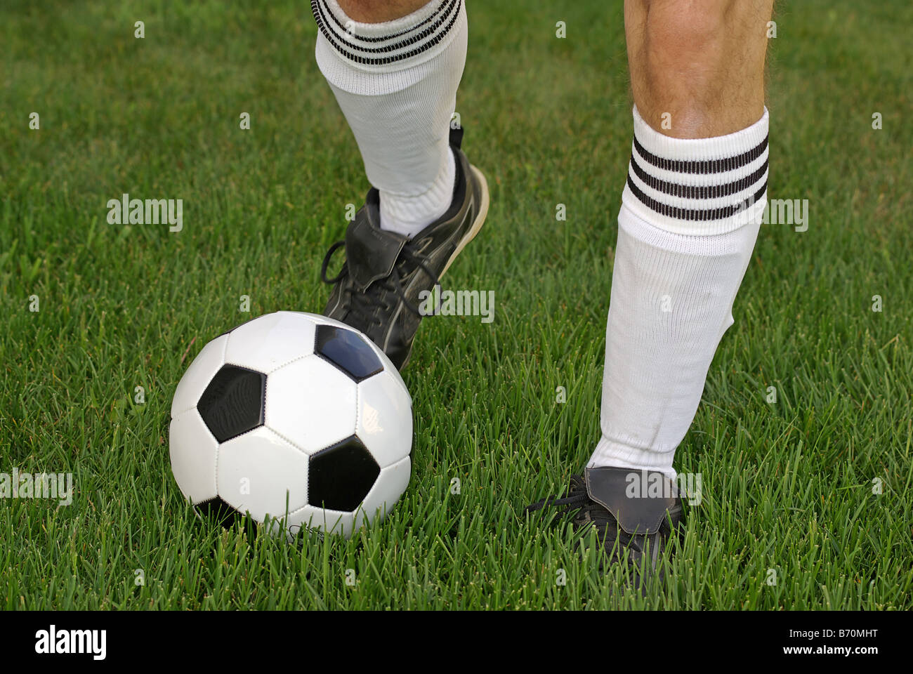 Fußball-Spieler den Ball auf der Wiese Stockfoto