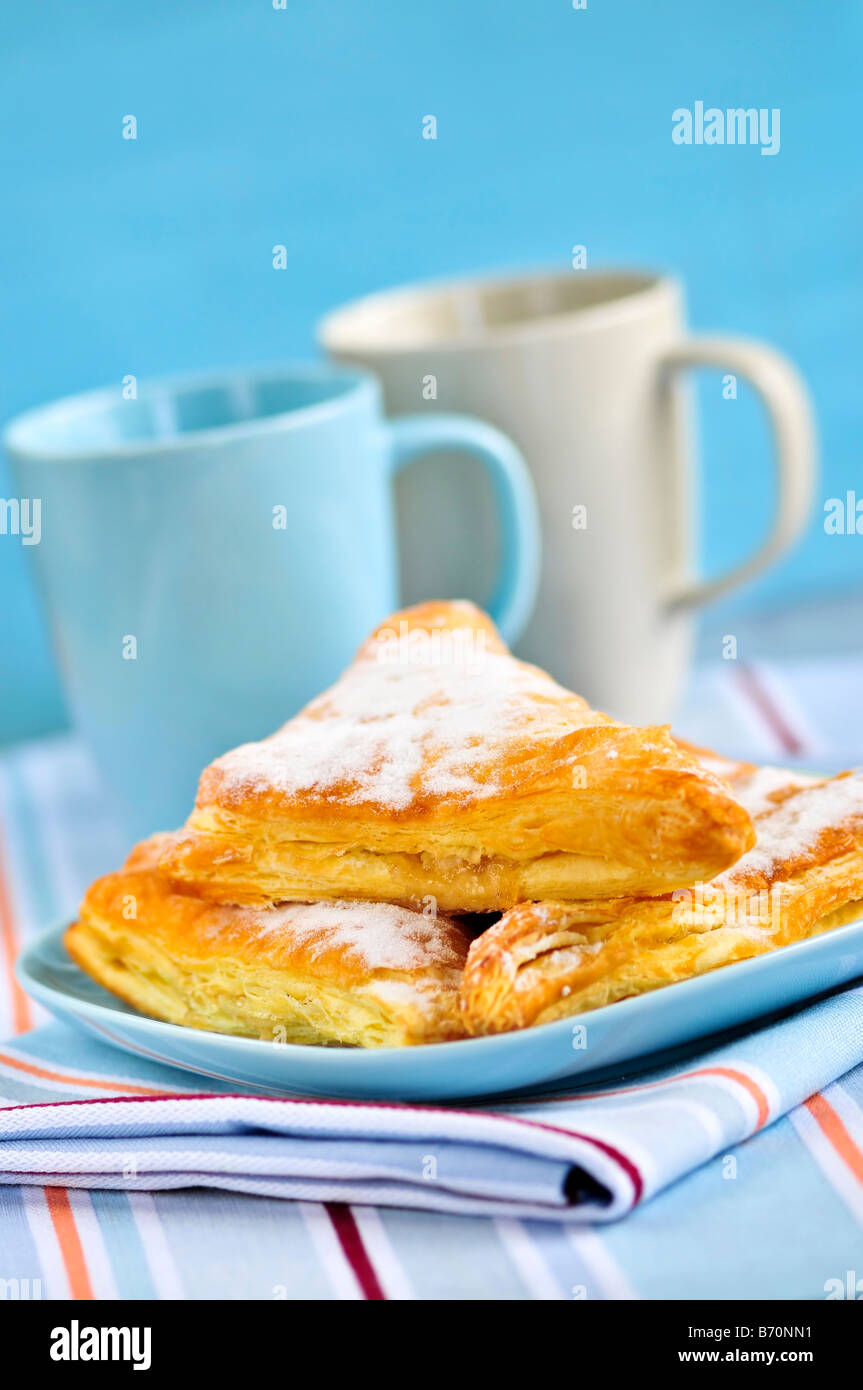 Apple-Umsätze-Gebäck mit Kaffeetassen im Hintergrund Stockfoto