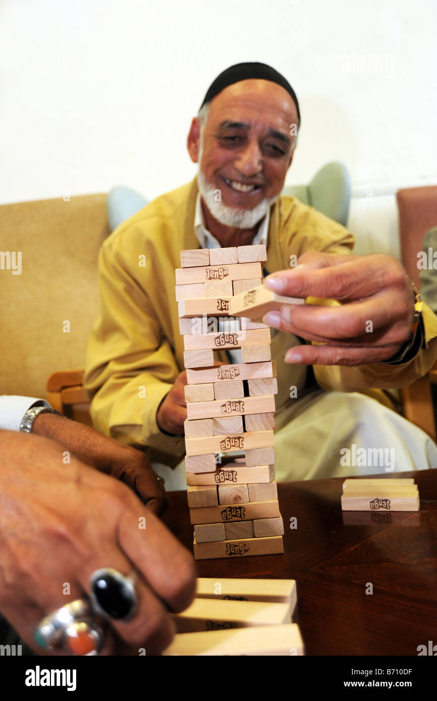 Ältere asiatische Männer spielen während ihrer Demenz Bewusstsein Fraktionssitzung Jenga Stockfoto