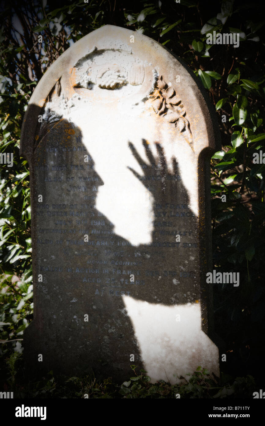 Bedrohliche Schatten eines Mannes auf einem alten Grabstein. (Körnig-Effekt). Stockfoto