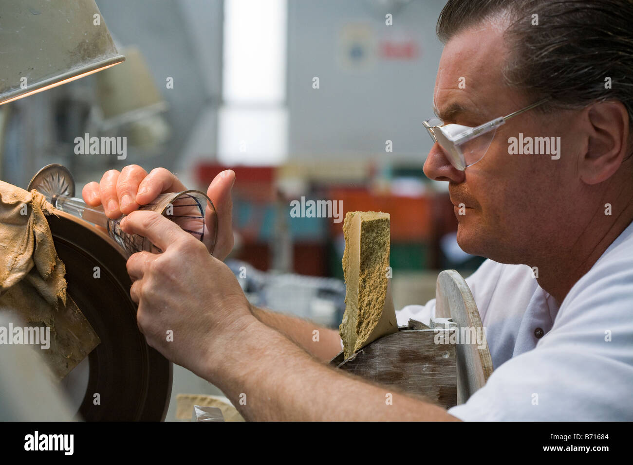 Crystal-Cutter: Ein Arbeiter in die Kristallfabrik schneidet eine genaue Muster in ein Glas Wein zu machen, eindeutig Waterford Stockfoto