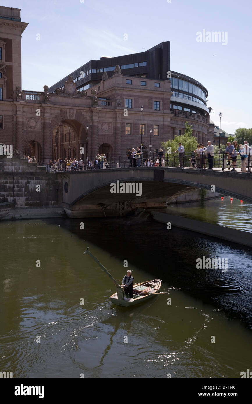 Mann Angeln auf dem Wasser neben dem House of Parliament in Stockholm Stockfoto