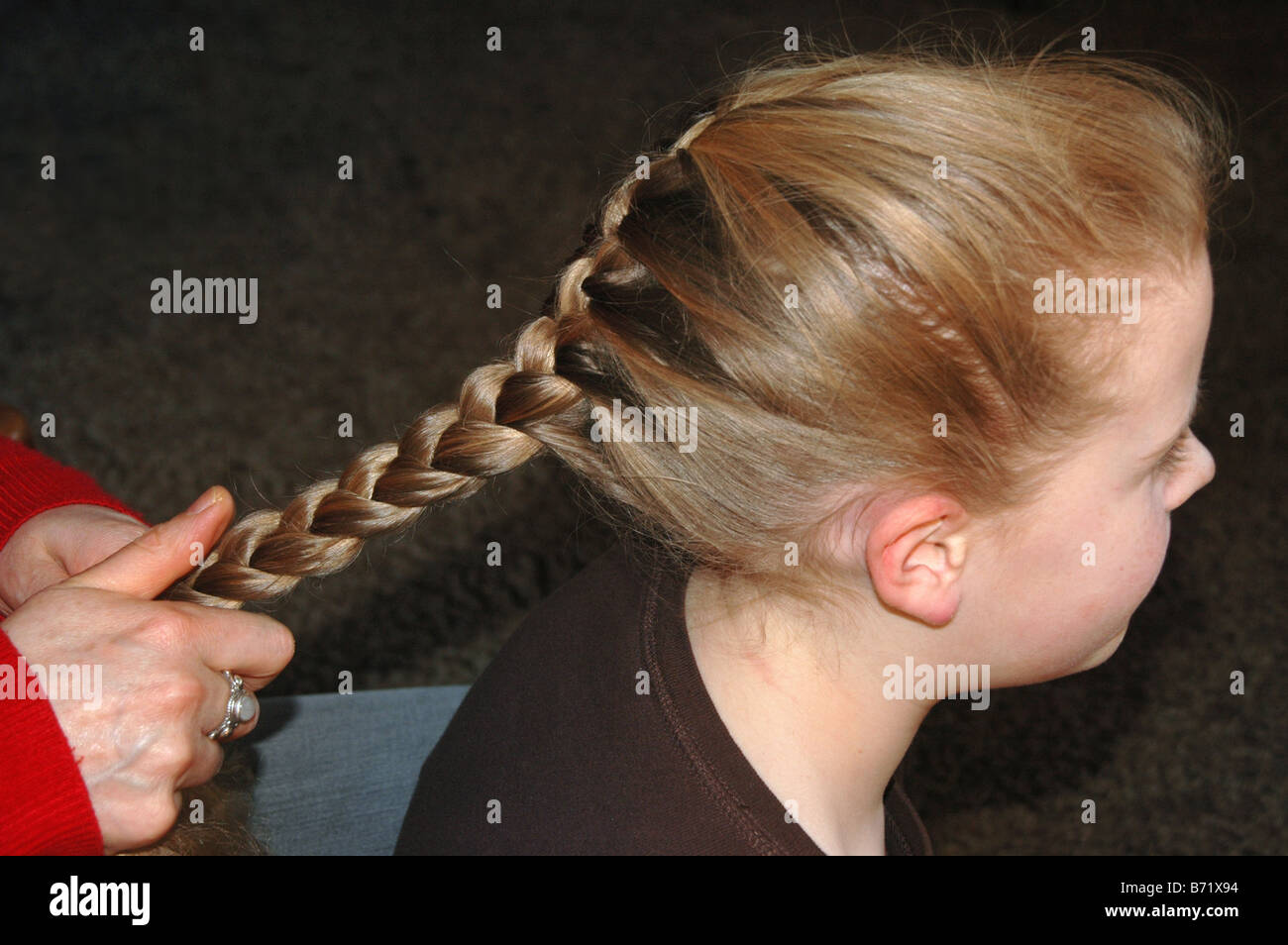 Ein junges Mädchen bekommt ihr Haar Plissee. Stockfoto