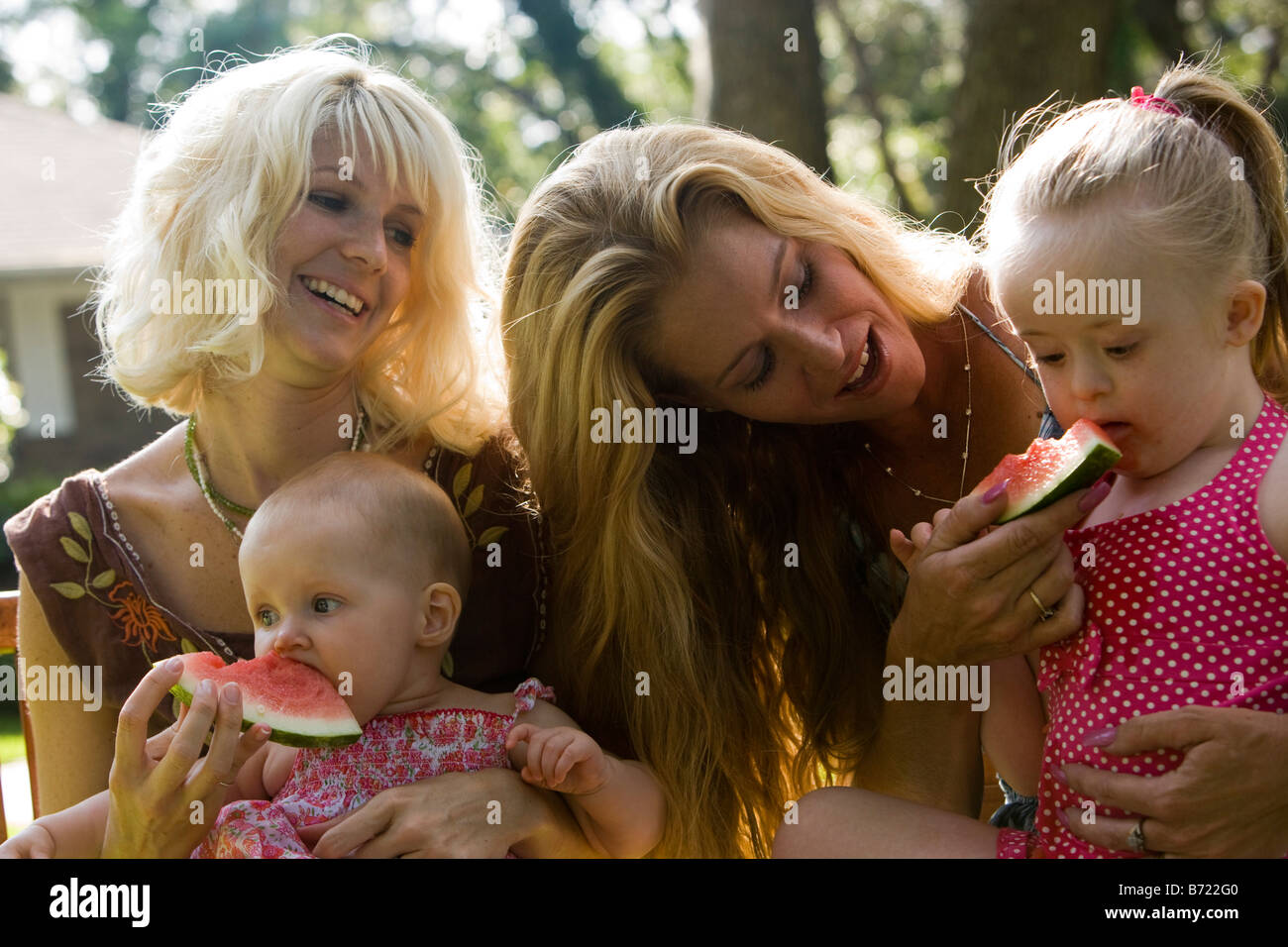 Mütter, die Verfütterung von Wassermelone an Baby und Kleinkind mit Down-Syndrom Stockfoto