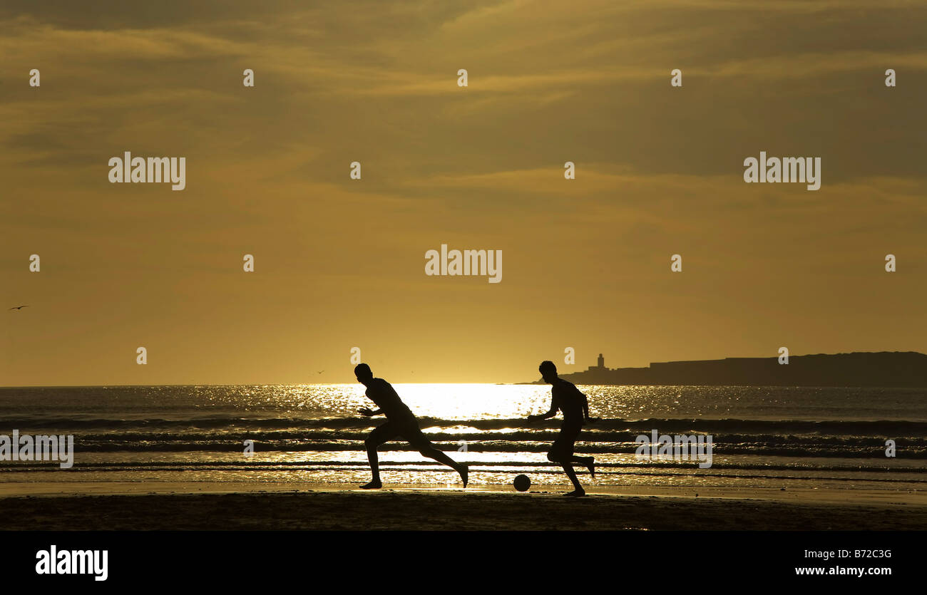Essaouira Marokko Strand Fußball Fußball Silhouette Sonnenuntergang Kinder Jugendliche spielen marokkanischen Küste Meeressand Stockfoto