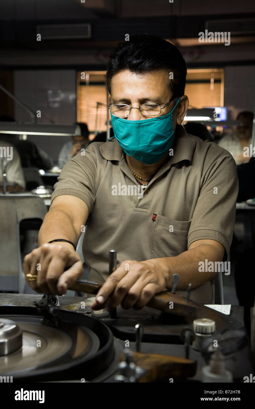 Diamant-Arbeiter Polieren ein Diamant beim Atmen durch eine Gesichtsmaske. Diamant-Workshop in der Stadt Surat, Gujarat. Indien Stockfoto