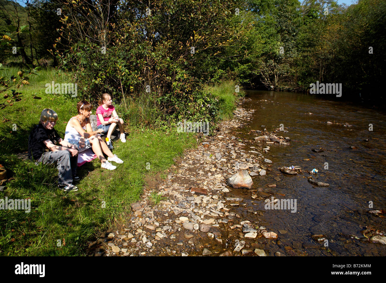 Familie picknicken am Ufer des Flusses Garw in Bryn Garw Landschaftspark Bridgend South Wales Stockfoto