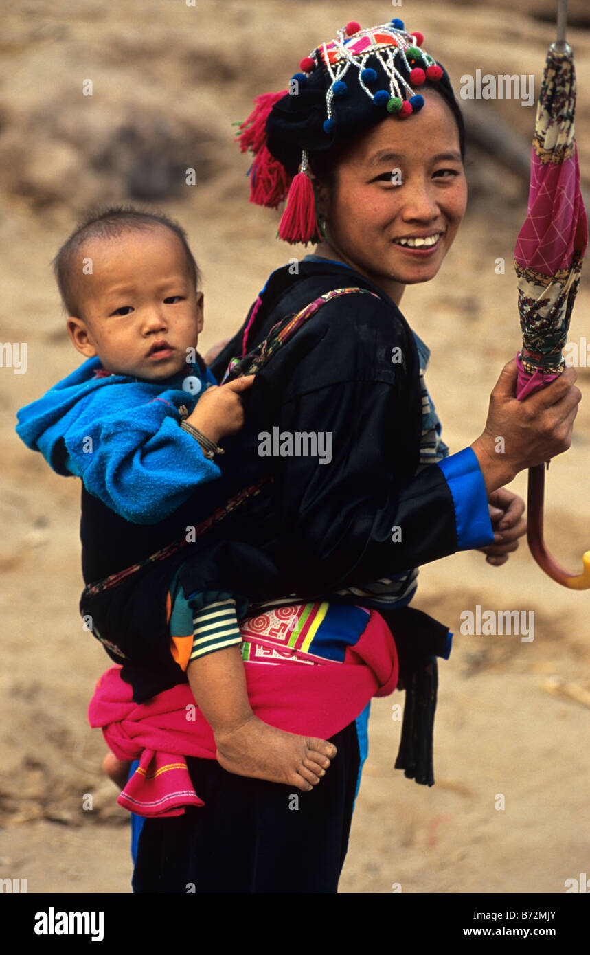 Ein Hmong Mädchen trägt ein Baby auf ihrem Rücken auf dem Lande in der Nähe von Luang Prabang, Nordlaos Stockfoto