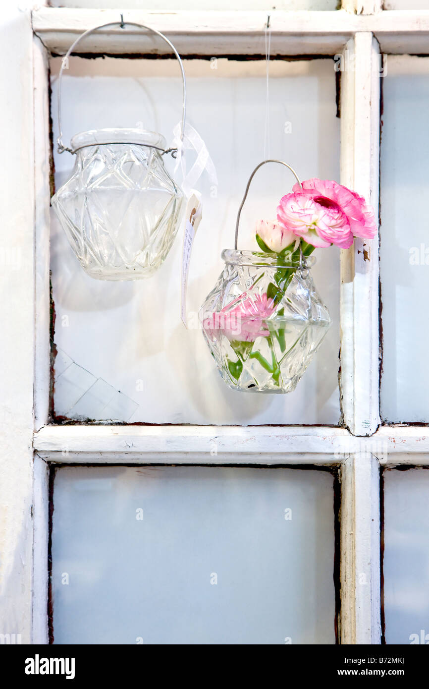 Zwei Vasen auf den Nägeln in der Fensterleiste aufgehängt Stockfoto