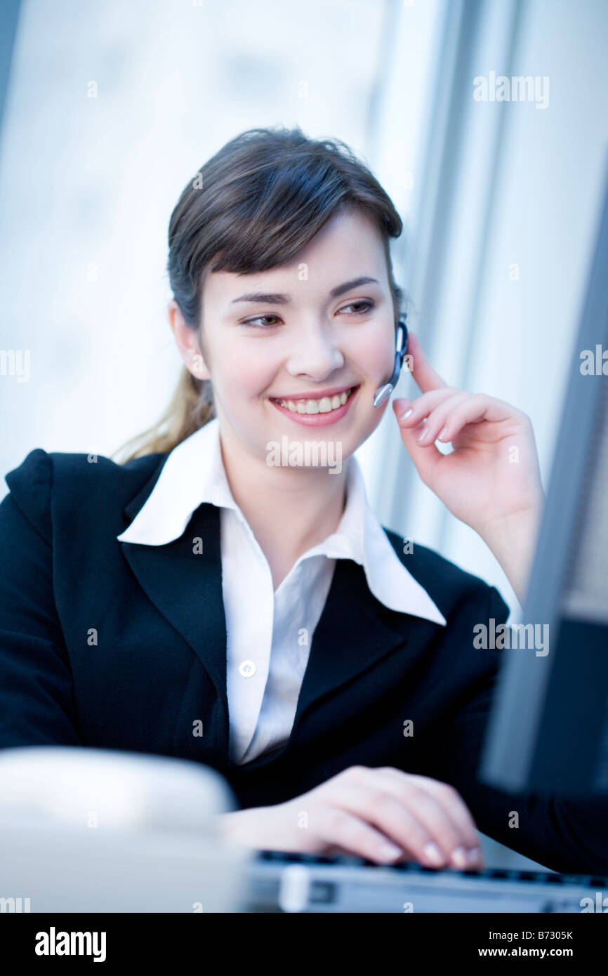 Junge Frau in festlich gekleidet mit bluetooth Stockfoto