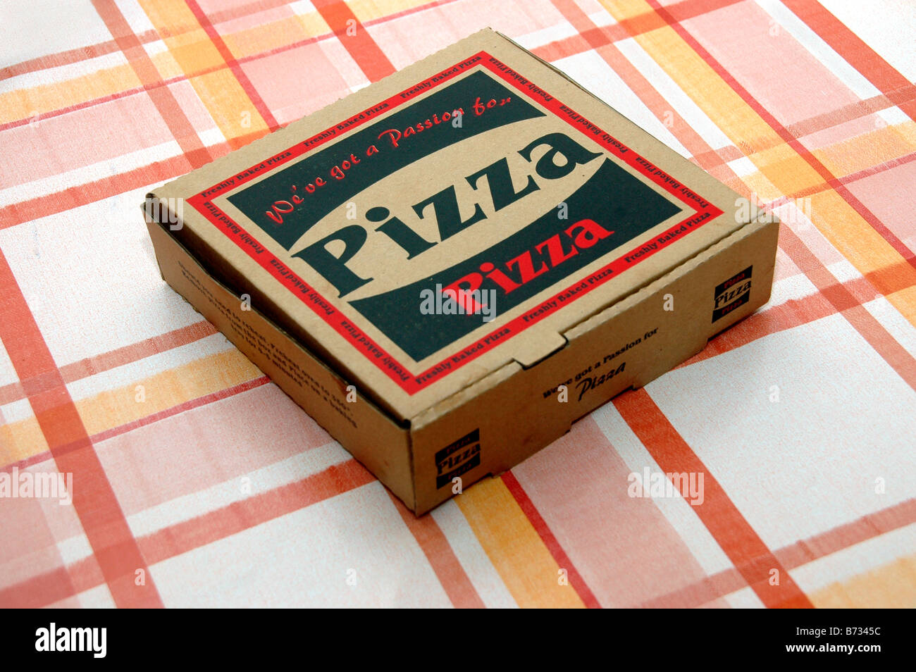 Eine Box Pizza zum Mitnehmen sitzt auf einem Küchentisch. Stockfoto