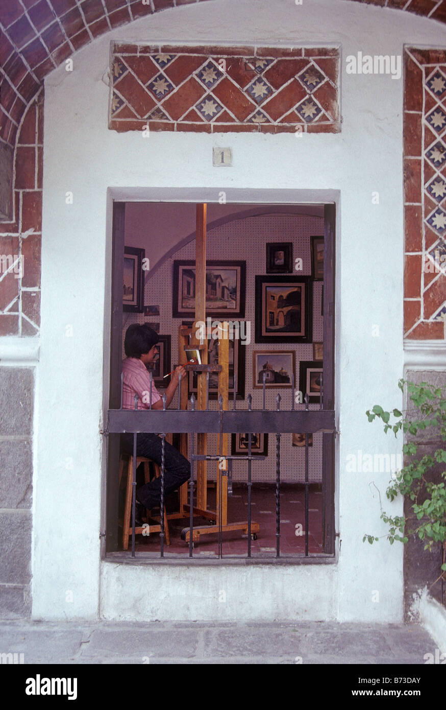 Künstler bei seiner Staffelei sitzen Malen ein Bild in seinem Studio, Barrio del Artista oder Künstler Viertel Stadt Puebla, Mexiko Stockfoto