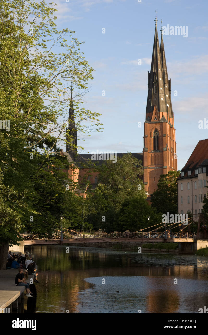 Menschen neben dem Fluss Fyris und der Kathedrale, Uppsala, Schweden Stockfoto