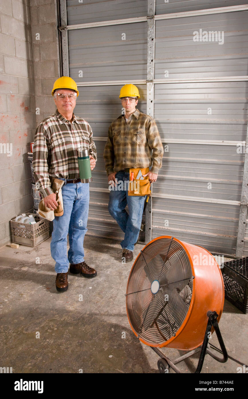 Männer tragen Schutzhelme mit Thermoskanne auf Baustelle Stockfotografie -  Alamy